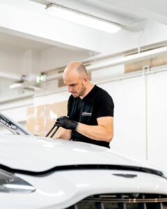 Technicien réalisant une pose de vitrage automobile externalisée